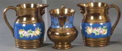 Conjunto de tres jarras vinateras de cerámica en reflejo metálico y decoración de flores esmaltadas. 
Inglaterra, Bristol. S. ff.XIX-pp.XX.
